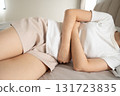 Young female suffering form stomachache while lying on bed at bedroom. Causes of abdominal pain include menstruation pain, gastritis, stomach ulcer, food poisoning, diarrhea or IBS. 131723835