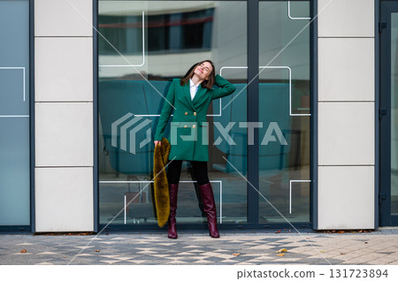 portrait of an elegantly dressed business woman at a glazed building in a financial district 131723894