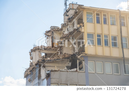Partially demolished office building with exposed floors, walls and debris. Urban decay and architectural transformation in progress. Partially demolished office building with exposed floors, walls and debris. Urban decay and architectural transformation in progress. 131724278