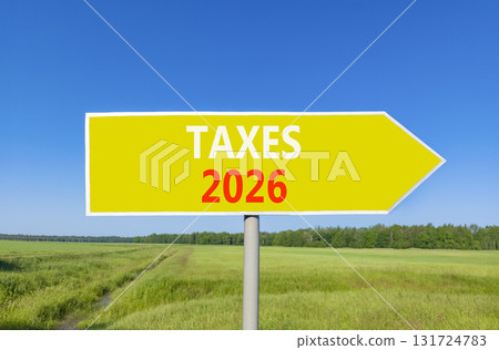 Taxes 2026 new year symbol. Concept words Taxes 2026 on beautiful yellow road sign. Beautiful green grass field forest and blue sky background. Business and taxes 2026 new year concept. Copy space. Taxes 2026 new year symbol. Concept words Taxes 2026 on beautiful yellow road sign. Beautiful green grass field forest and blue sky background. Business and taxes 2026 new year concept. Copy space. 131724783