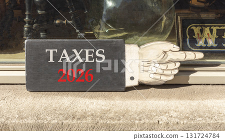 Taxes 2026 new year symbol. Concept words Taxes 2026 on beautiful black wooden hand sign. Beautiful shop display background. Business and taxes 2026 new year concept. Copy space. 131724784