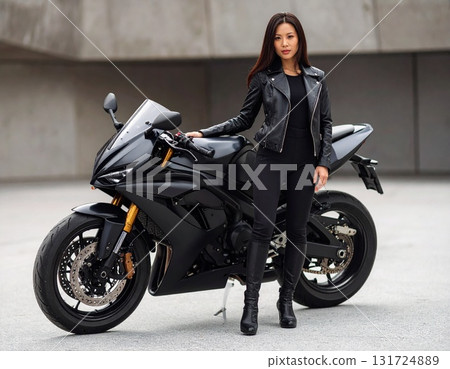 Woman standing next to a black sports bike 131724889