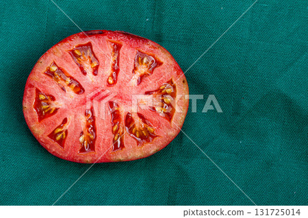 green tomato halve on a red background, closeup from above green tomato halve on a red background, closeup from above 131725014