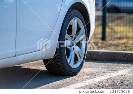 close up of the rear wheel of a white vehicle parked on the side of the street close up of the rear wheel of a white vehicle parked on the side of the street 131725026
