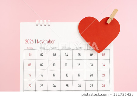 November 2026 desk calendar with red heart note on pink color background. November 2026 desk calendar with red heart note on pink color background. 131725423