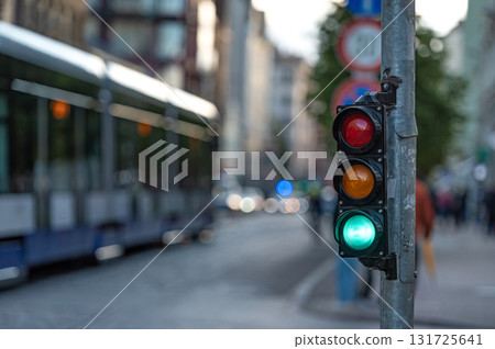 view of city traffic with traffic lights, in the foreground a semaphore with a green light, closeup 131725641