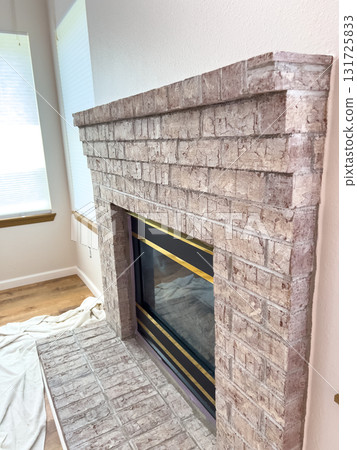 A side view of a brick fireplace showing the stacked edge design and clean alignment. The image includes a soft-lit living room environment. A side view of a brick fireplace showing the stacked edge design and clean alignment. The image includes a soft-lit living room environment. 131725833