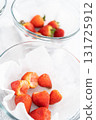 Freshly washed and dried strawberries are carefully arranged in a glass bowl lined with paper towel, ready for snacking or further use. 131725912
