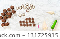 The first step of decorating gingerbread star cookies, showing royal icing tools, including a piping bag filled with white royal icing, placed next to the baked cookies. 131725915