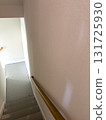 White-painted stairwell with a wooden handrail, transitioning into a gray-painted concrete basement floor. Ideal for remodeling or safety features guides. 131725930