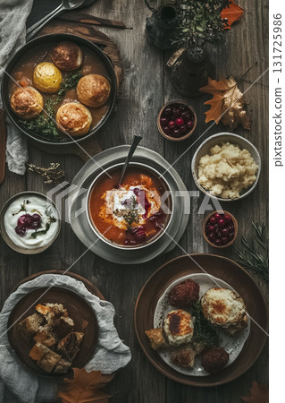 An overhead view of a rustic autumn table spread with soup, cranberry-topped mashed potatoes, soft rolls, and cozy fall details. Designed for Thanksgiving themes, food blogs, or seasonal ads. 131725986