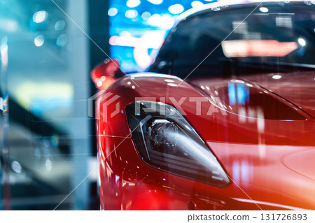 Bold Red Sports Car Front View in Showroom Spotlight, Striking Crimson Performance Vehicle Head-On at Exhibition Display Bold Red Sports Car Front View in Showroom Spotlight, Striking Crimson Performance Vehicle Head-On at Exhibition Display 131726893