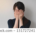 A woman who covers her face by hand 131727241