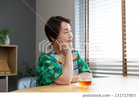 一位老年婦女的側面像，她靠著下巴，直視前方 131727803