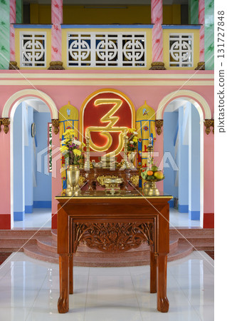 A gilded altar with gilded vases, flowers and religious symbol in the temple of Khao Dai religion 131727848