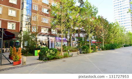 Warsaw, Poland. 21 September 2025. Chmielna in downton lined with granite slabs and planted with plants and shrubs street. City promenade during summer day. City architecture with shops and greenery. 131727953