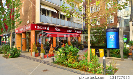 Warsaw, Poland. 21 September 2025. Chmielna in downton lined with granite slabs and planted with plants and shrubs street. City promenade during summer day. City architecture with shops and greenery. 131727955