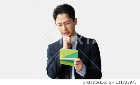 Male businessman thinking while looking at his bankbook 131728975