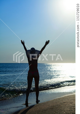 Woman in bikini walking on the beach 131729010