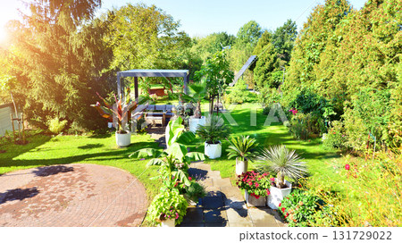 Beautiful summer garden with green grass, exotic plants and aluminum pergola. Professional luxury gardening concept. Beautiful summer garden with green grass, exotic plants and aluminum pergola. Professional luxury gardening concept. 131729022