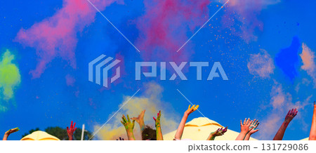 At the color Holi festival, hands in the air, blue sky behind At the color Holi festival, hands in the air, blue sky behind 131729086