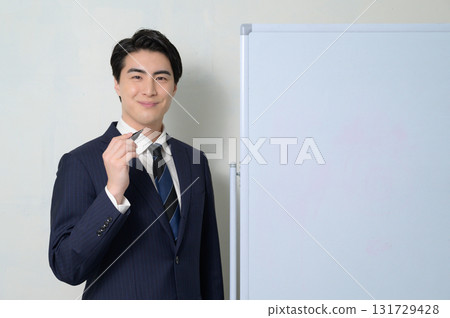 A man giving a presentation in front of a whiteboard 131729428