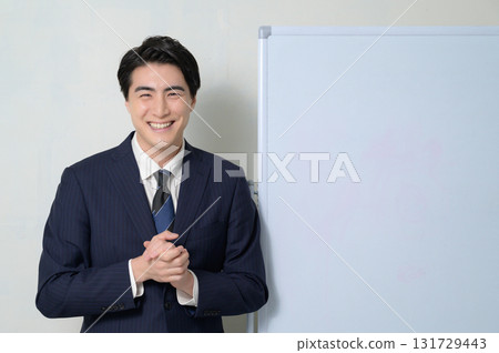 A man giving a presentation in front of a whiteboard 131729443