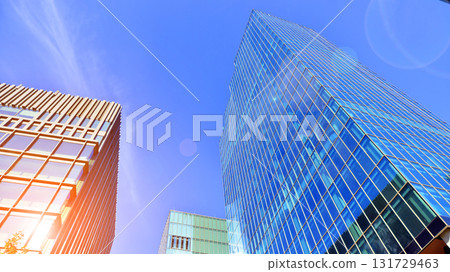 Bottom up view of modern glass office building. Commercial real estate. New commercial office building in modern city. Bottom up view of modern glass office building. Commercial real estate. New commercial office building in modern city. 131729463