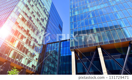Bottom up view of modern glass office building. Commercial real estate. New commercial office building in modern city. Bottom up view of modern glass office building. Commercial real estate. New commercial office building in modern city. 131729471