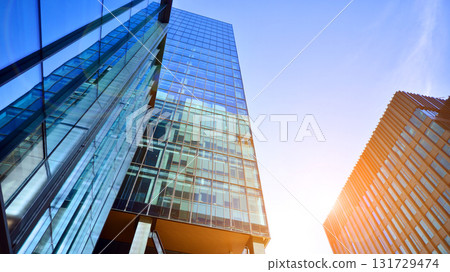 Bottom up view of modern glass office building. Commercial real estate. New commercial office building in modern city. Bottom up view of modern glass office building. Commercial real estate. New commercial office building in modern city. 131729474