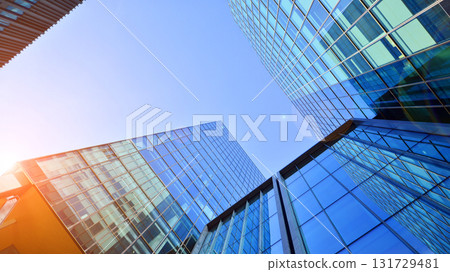 Bottom up view of modern glass office building. Commercial real estate. New commercial office building in modern city. Bottom up view of modern glass office building. Commercial real estate. New commercial office building in modern city. 131729481