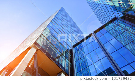 Bottom up view of modern glass office building. Commercial real estate. New commercial office building in modern city. Bottom up view of modern glass office building. Commercial real estate. New commercial office building in modern city. 131729483