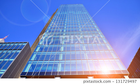 Bottom up view of modern glass office building. Commercial real estate. New commercial office building in modern city. Bottom up view of modern glass office building. Commercial real estate. New commercial office building in modern city. 131729497