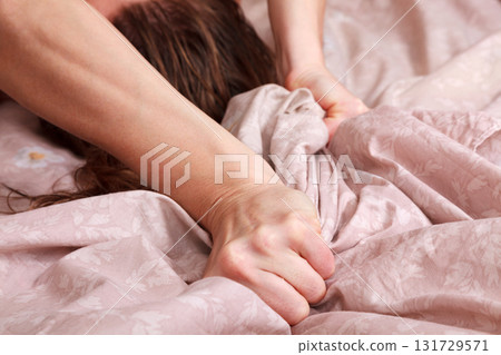 Closeup shot of hands of woman pulling the sheets in ecstasy, orgasm. Closeup shot of hands of woman pulling the sheets in ecstasy, orgasm. 131729571