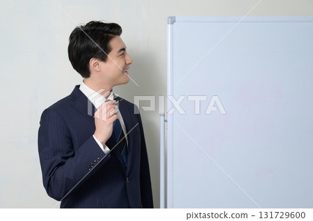 A man giving a presentation in front of a whiteboard 131729600