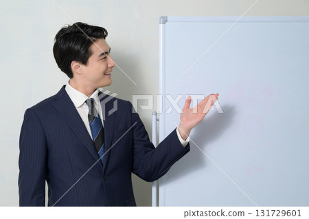 A man giving a presentation in front of a whiteboard A man giving a presentation in front of a whiteboard 131729601