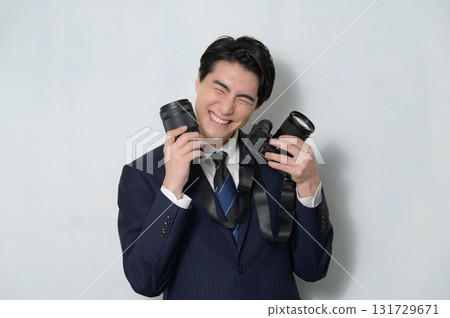 Happy man holding a camera Happy man holding a camera 131729671