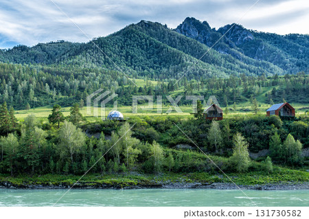 A turquoise river and picturesque forested mountains. Glamping on the riverbank A turquoise river and picturesque forested mountains. Glamping on the riverbank 131730582