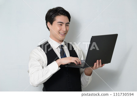 Man holding a laptop on a white background 131730594