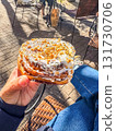 Hand Holding Sweet Pastry with Nuts and Icing 131730706