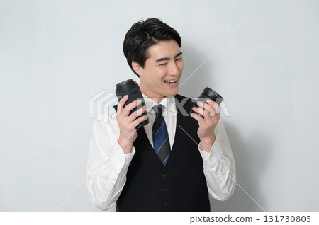 A man holding a camera lens and worrying 131730805