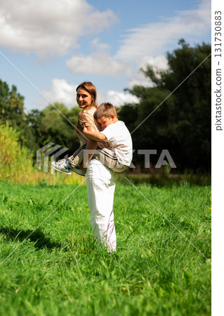 Playful parenting moment. Mom and preschool son dance and play together outside on summer day. Perfect illustration of carefree childhood joy. Playful parenting moment. Mom and preschool son dance and play together outside on summer day. Perfect illustration of carefree childhood joy. 131730883