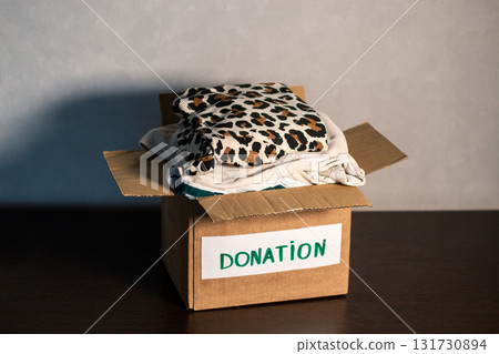 Woman gives her old clothes to charity, helping people in need who are caught up in military action. Woman gives her old clothes to charity, helping people in need who are caught up in military action. 131730894