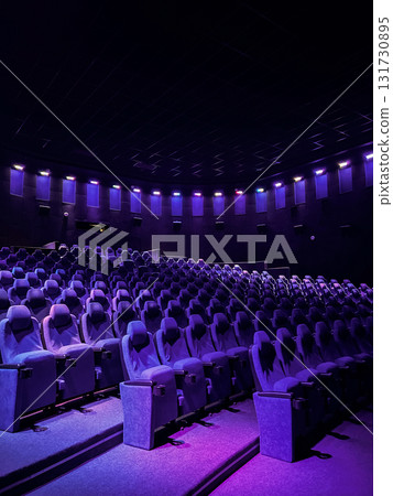 Vertical image of Cinema auditorium with empty purple chairs. Comfortable seats in movie theatre. Cinema interior. Vertical image of Cinema auditorium with empty purple chairs. Comfortable seats in movie theatre. Cinema interior. 131730895