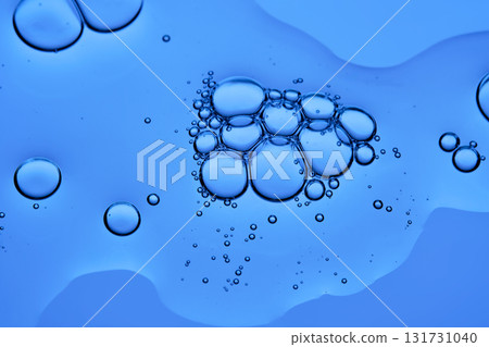 The texture of a cosmetic serum with bubbles on a blue background. 131731040