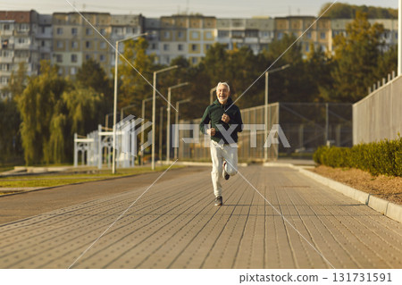 Healthy sporty fitness mature man running outdoors training for wellness, health and cardio Healthy sporty fitness mature man running outdoors training for wellness, health and cardio 131731591