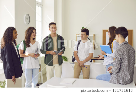Group of a young school or college students standing together in classroom and talking. Group of a young school or college students standing together in classroom and talking. 131731613