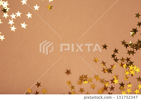 Golden glitter stars on brown background Golden glitter stars on brown background 131732347