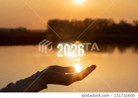 Future hope held in hand over sunset water view. 131732600