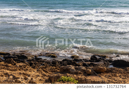 Turquoise sea waves and rocks under the bright sun Turquoise sea waves and rocks under the bright sun 131732764
